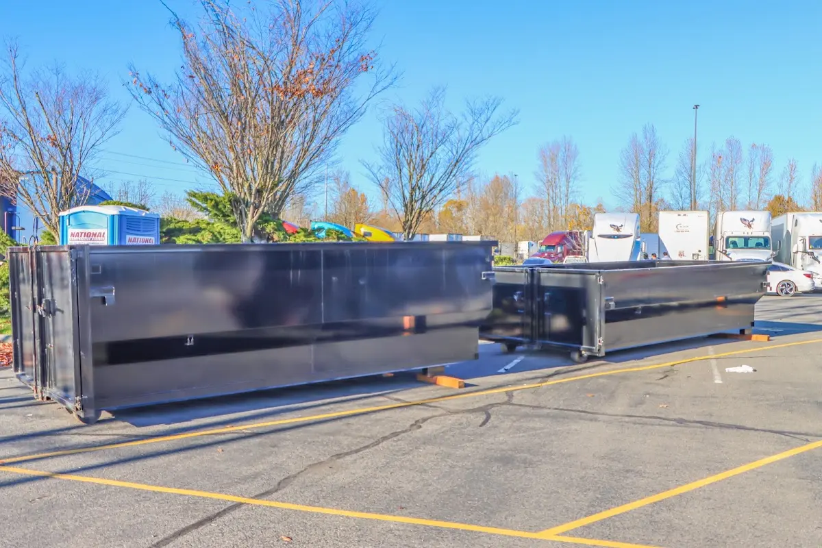 Professional dumpster rental service with roll-off container on residential driveway in West Point